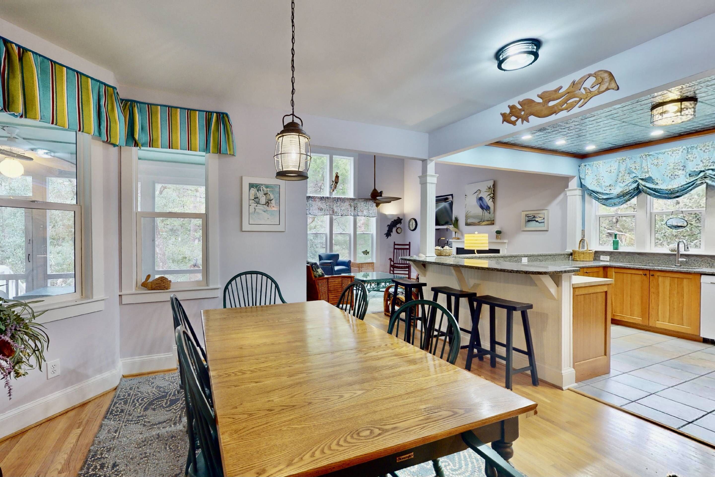 A spacious kitchen with a wooden dining table, bar stools, and a large island.