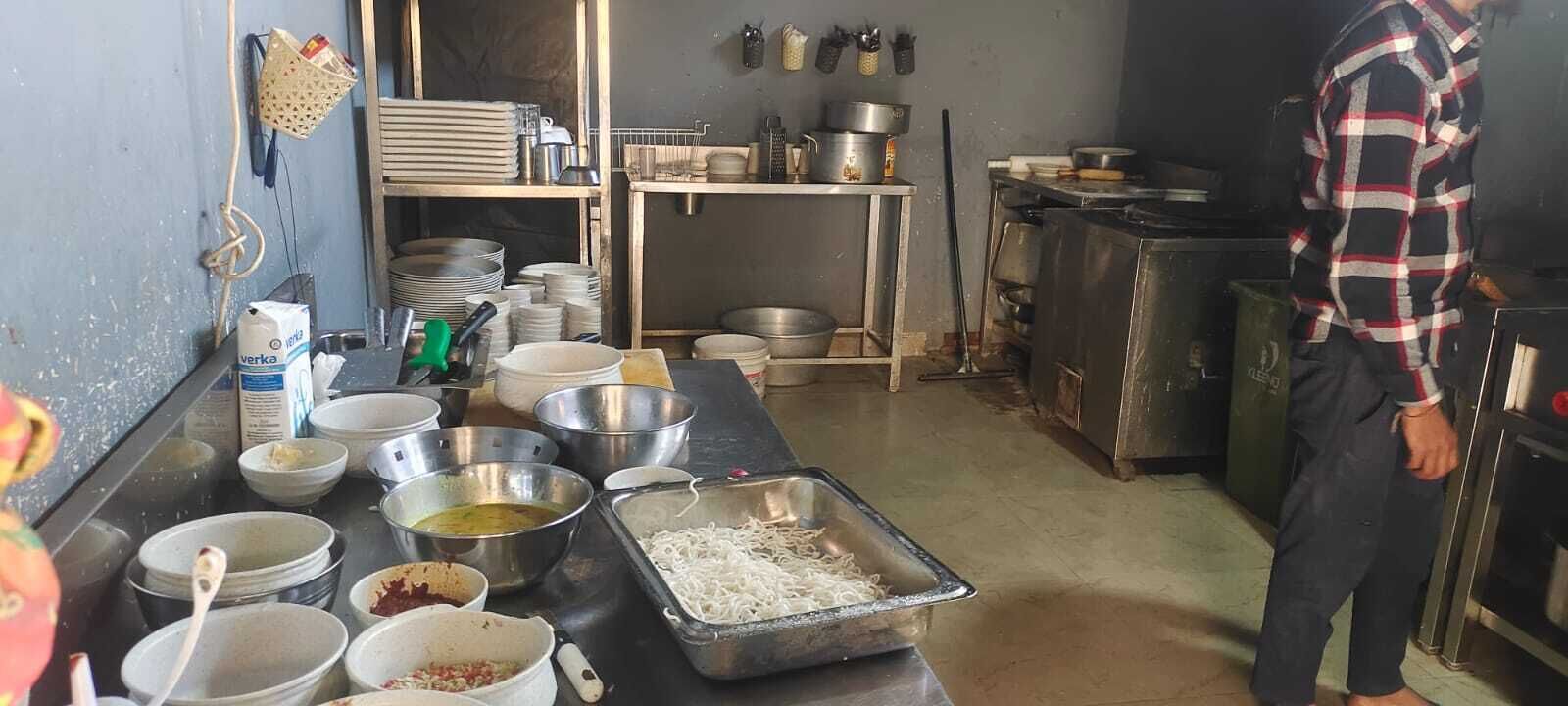 Une cuisine équipée de divers ustensiles de cuisine, de casseroles et de bols posés sur le plan de travail.