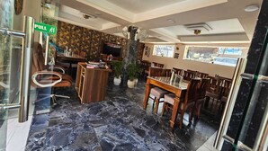Ein Restaurant mit Marmorboden, Holzmöbeln und einem grünen Fluchtwegschild.