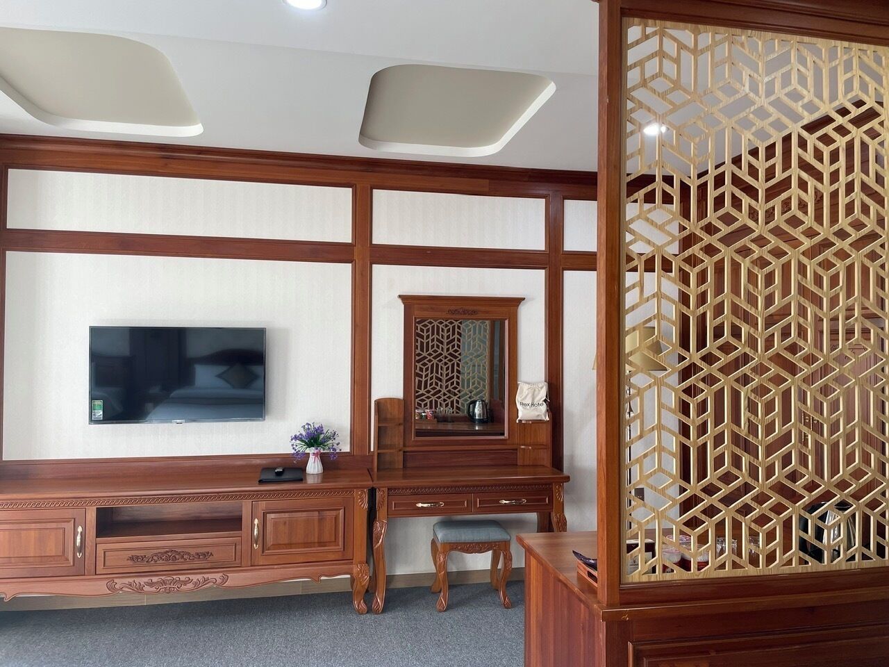 Een traditionele Japanse kamer met een houten bureau, televisie en decoratieve schermen.