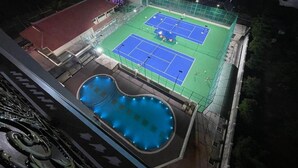 An indoor tennis court with a pool adjacent to it. - Rex Hotel Binh Dinh - by BAY LUXURY (Binh Dinh)