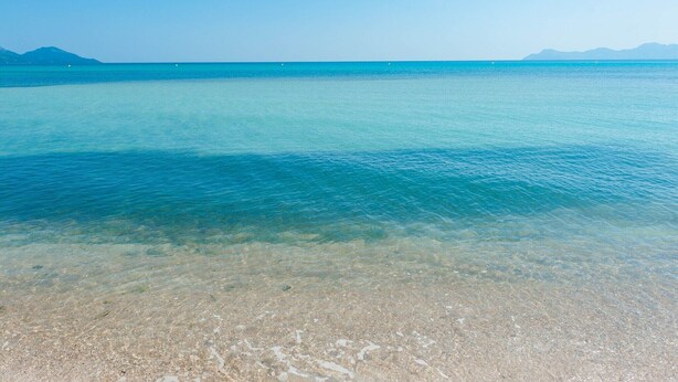 A clear view of a beach with shallow water and a distant mountain range. - Can Melis - Villa With Private Pool In Campanet (Campanet, Illes Balears)