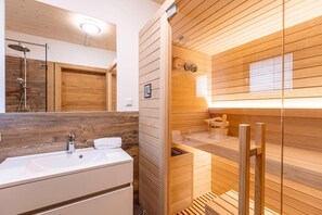 Bathroom features a large sink, mirror, and glass-enclosed shower area.