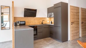Una cucina compatta con forno a microonde, forno e mobili in legno.