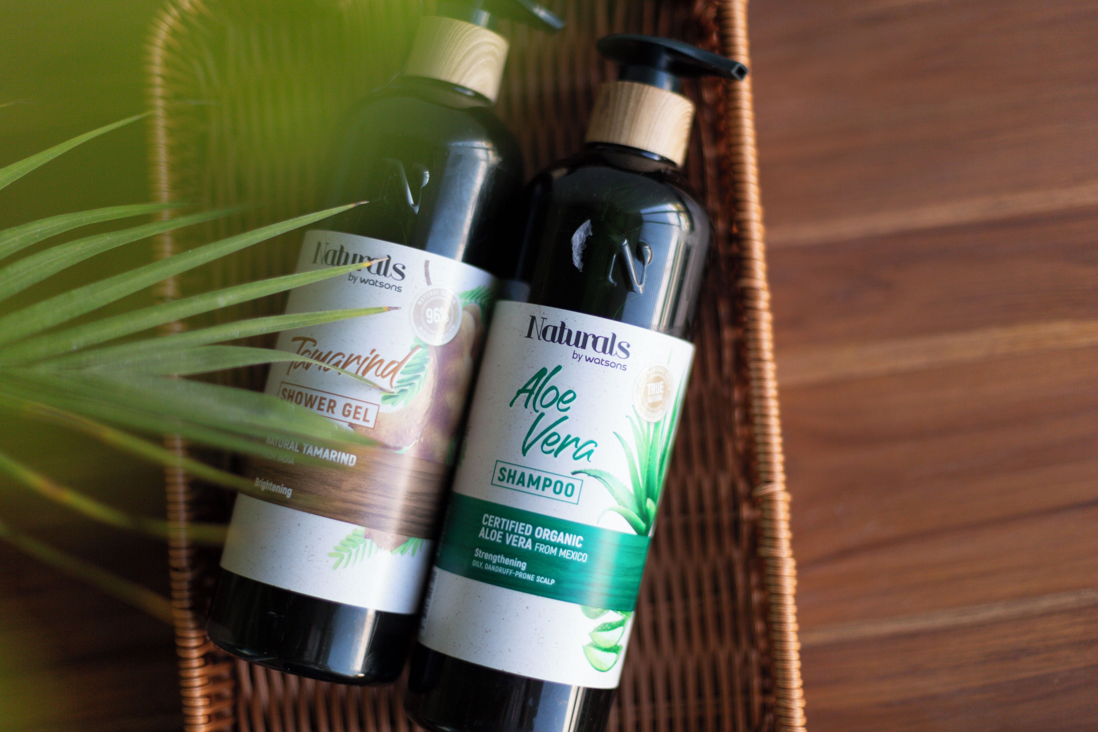 Two bottles of shampoo in a wicker basket.