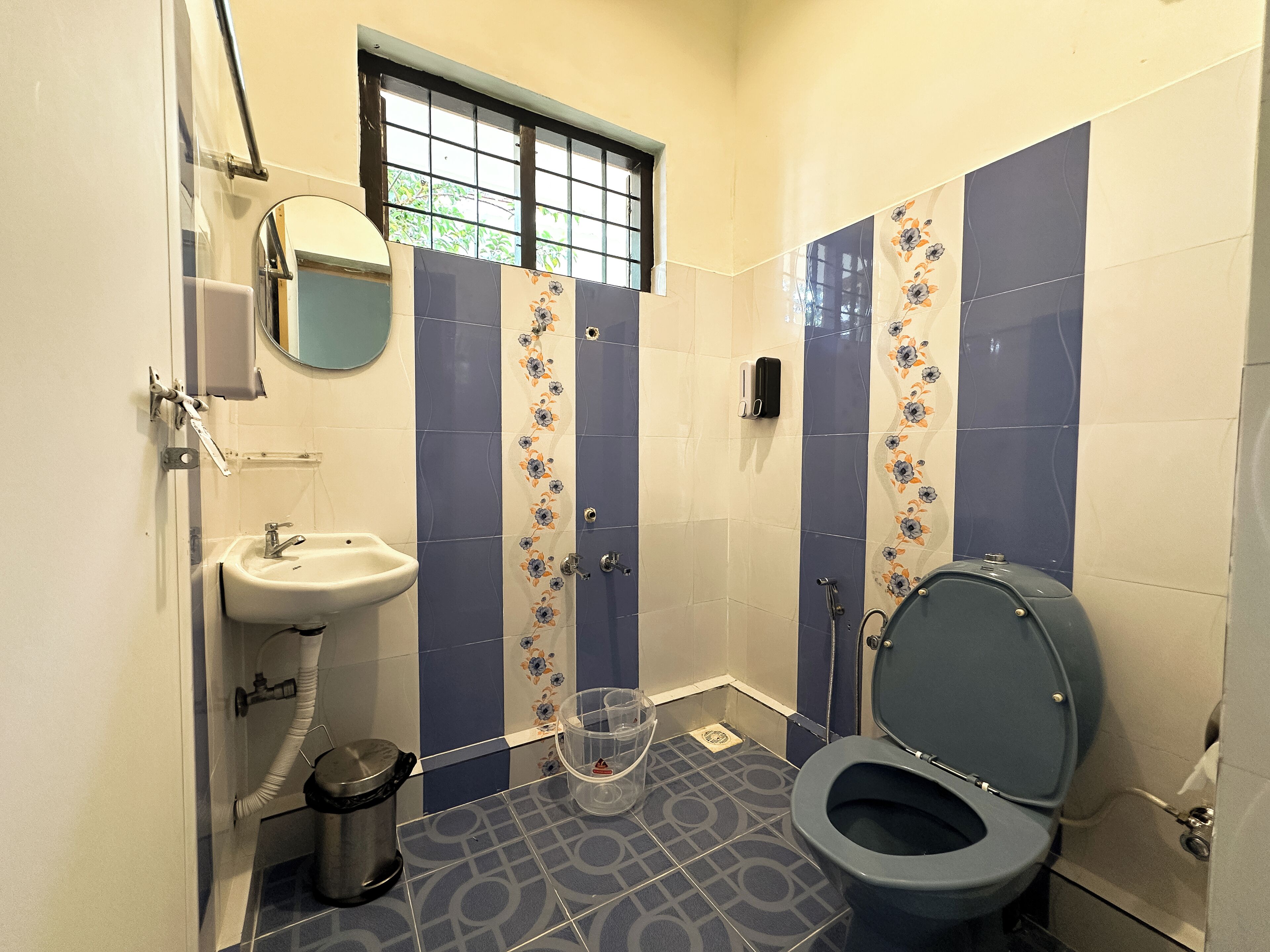 A bathroom with a sink, toilet, and window.