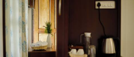 A wooden cabinet with a white vase and a basket of folded towels.