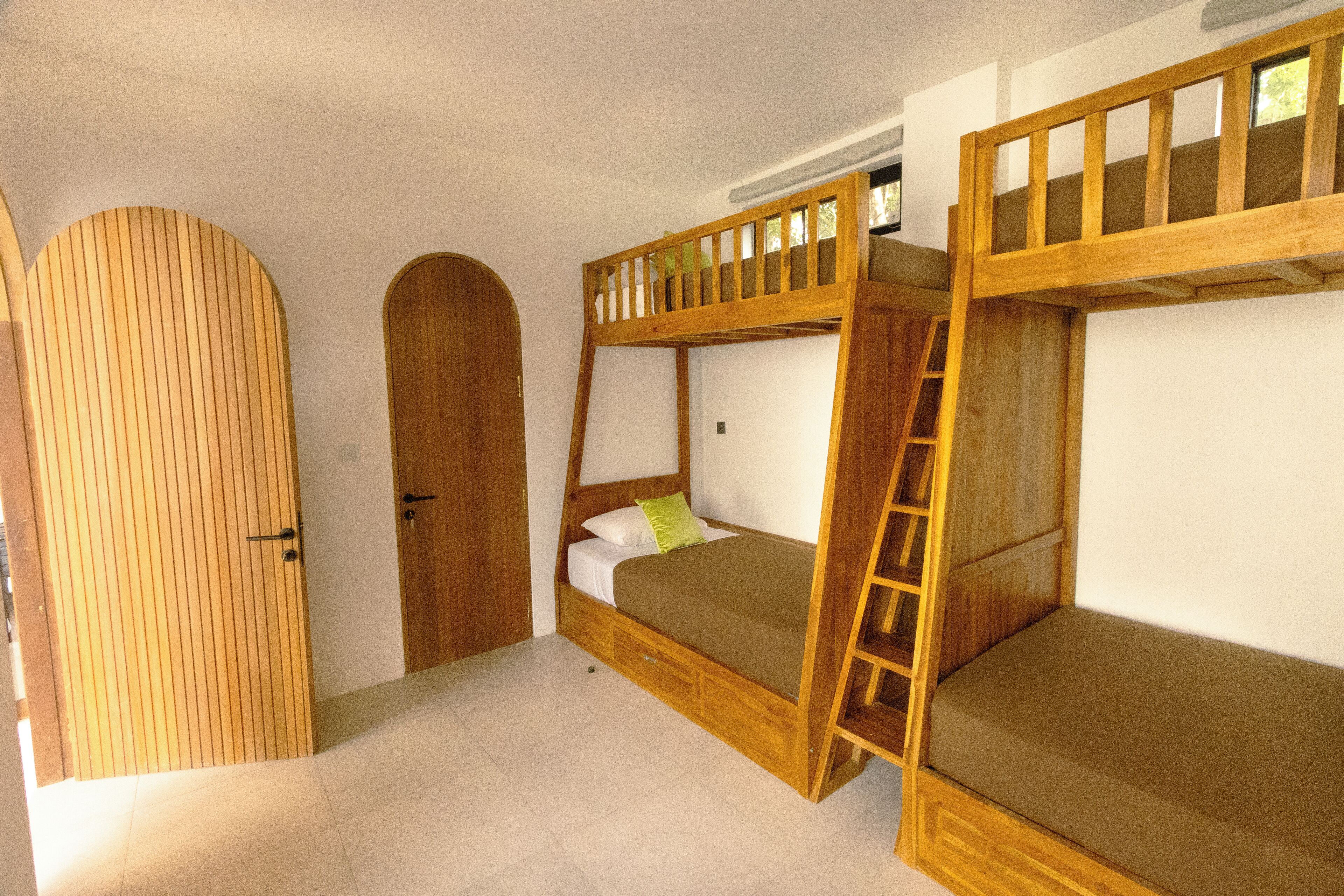 Ein Zimmer mit Etagenbetten, Holztüren und einer Leiter.