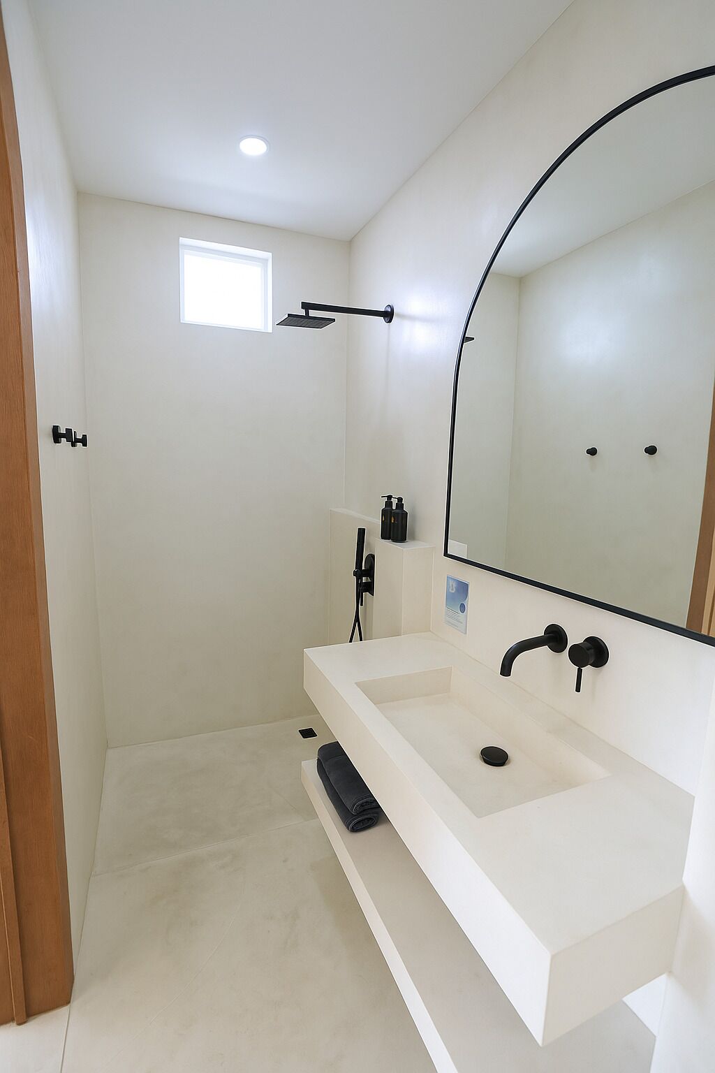 Un baño moderno con un espejo grande, dos lavamanos y una zona de ducha.
