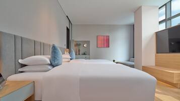 Quarto de hotel moderno com cama, mesa de cabeceira, abajur e uma janela ampla.