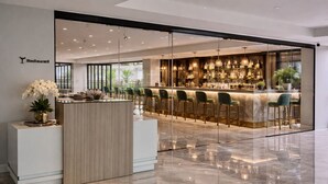 Un restaurant moderne doté d’un bar, de cloisons en verre et d’un comptoir d’accueil.