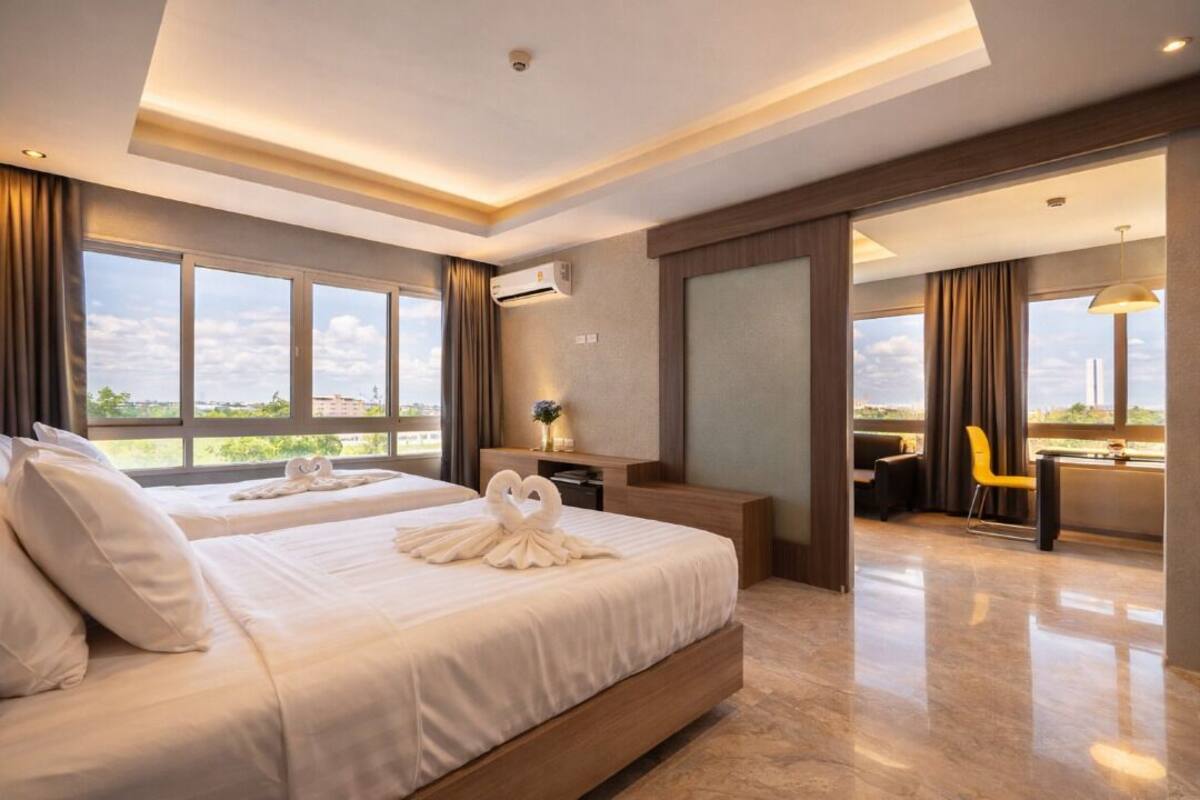 Een moderne hotelkamer met een groot bed, een bureau en uitzicht op de stad.