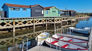 A wooden pier with colorful wooden buildings, boats docked, and calm water. - Awesome home in Saint-Pierre-d'Oléron with WiFi (Saint-Pierre-d'Oléron)