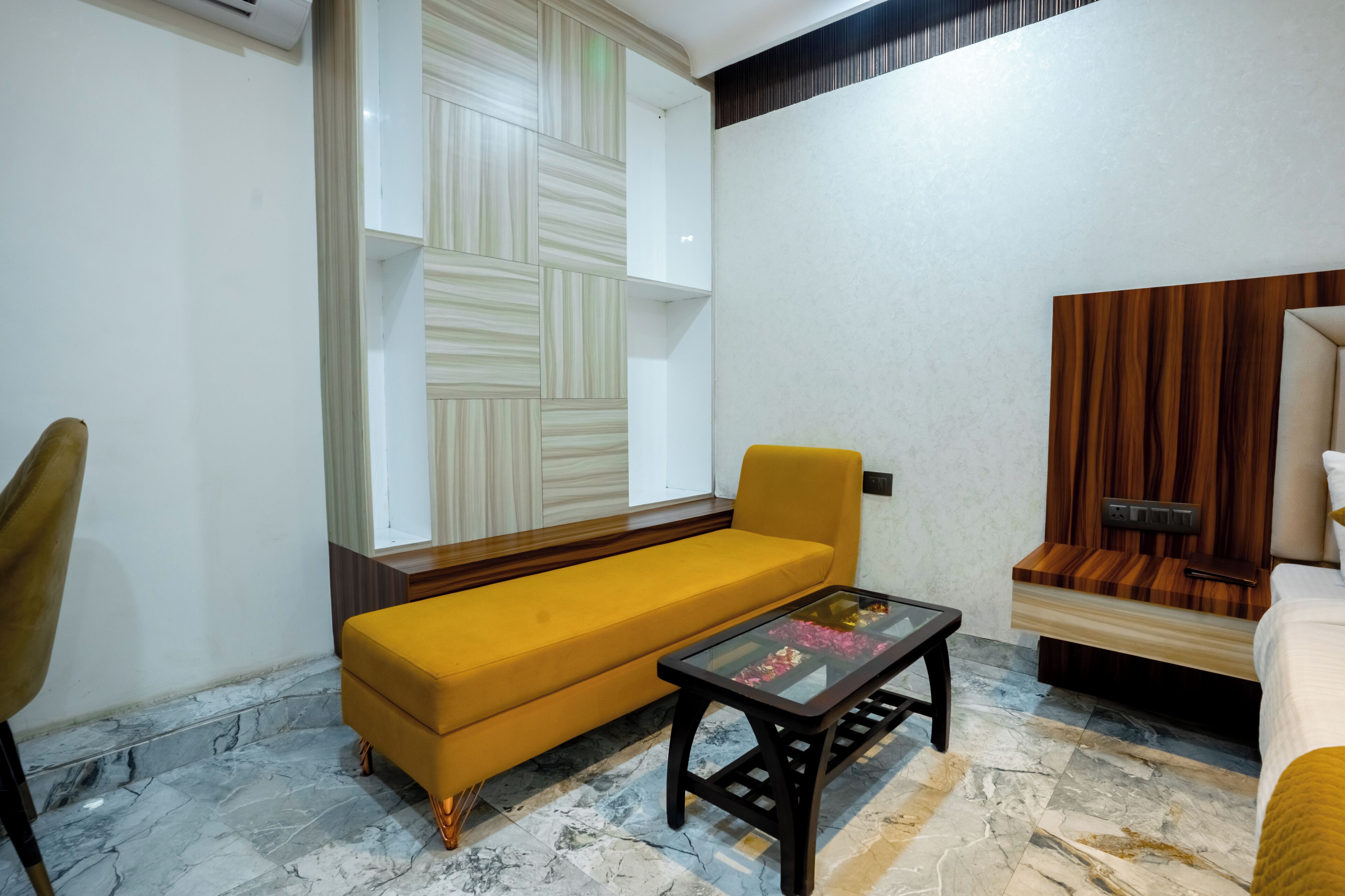 Un salon avec un canapé, une table basse en verre et un mur décoratif en bois.