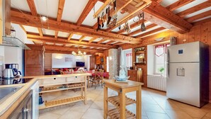 A rustic kitchen with wooden beams, a central island, and a refrigerator. - Pet friendly home in Fourches with sauna (Fourches)