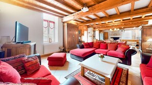A cozy living room with a sectional sofa, a flat-screen TV, and a fireplace. - Pet friendly home in Fourches with sauna (Fourches)