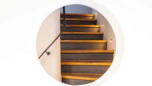 A circular view of a staircase with wooden steps and a metal handrail. - Sylt Rooms 10 - Shelter Island - Westerland (Westerland)