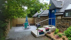 A stone building with a blue door and a sign reading "Les Agapanthes."