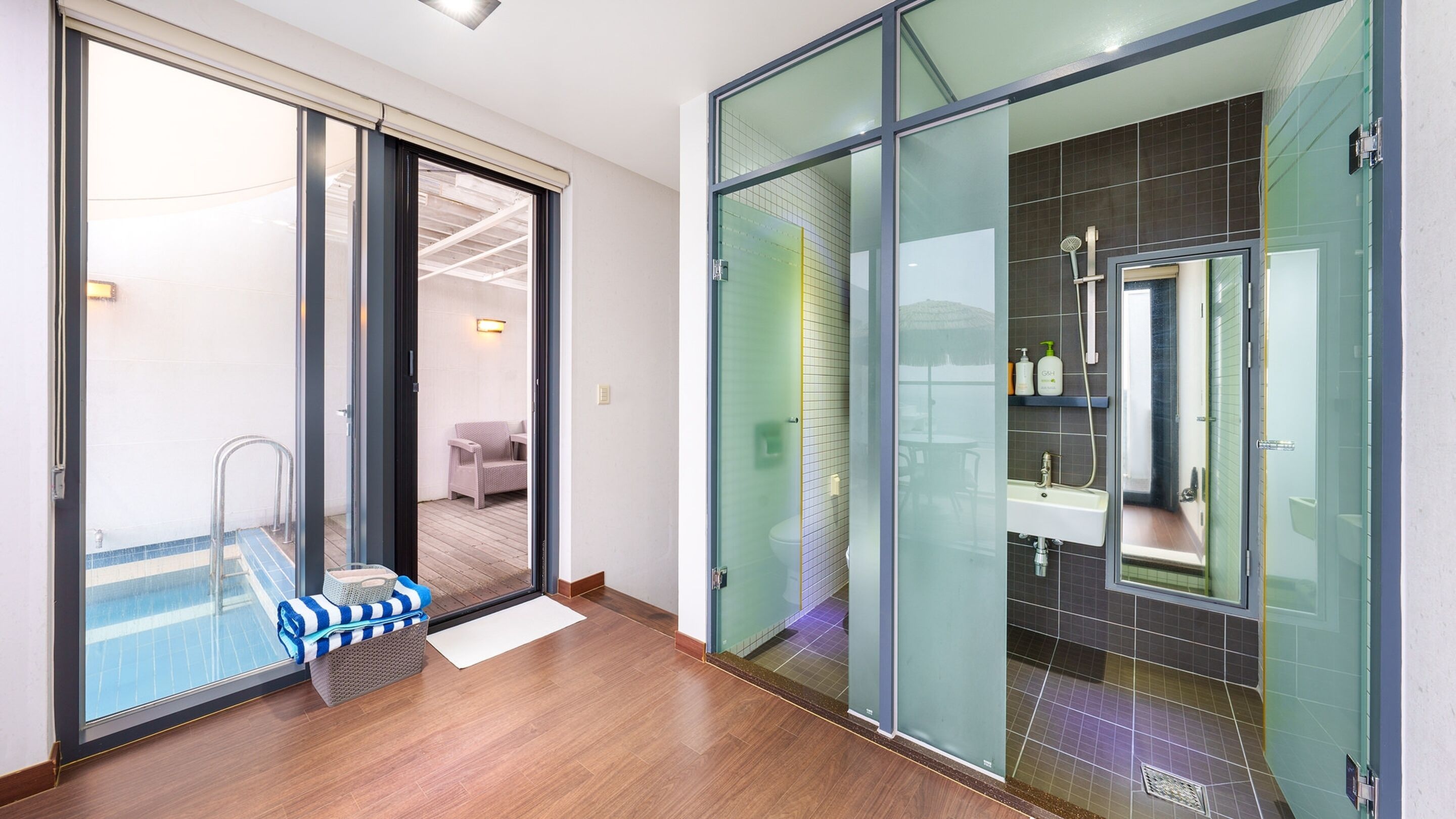 A modern bathroom with a glass shower enclosure, a sink, and a toilet.