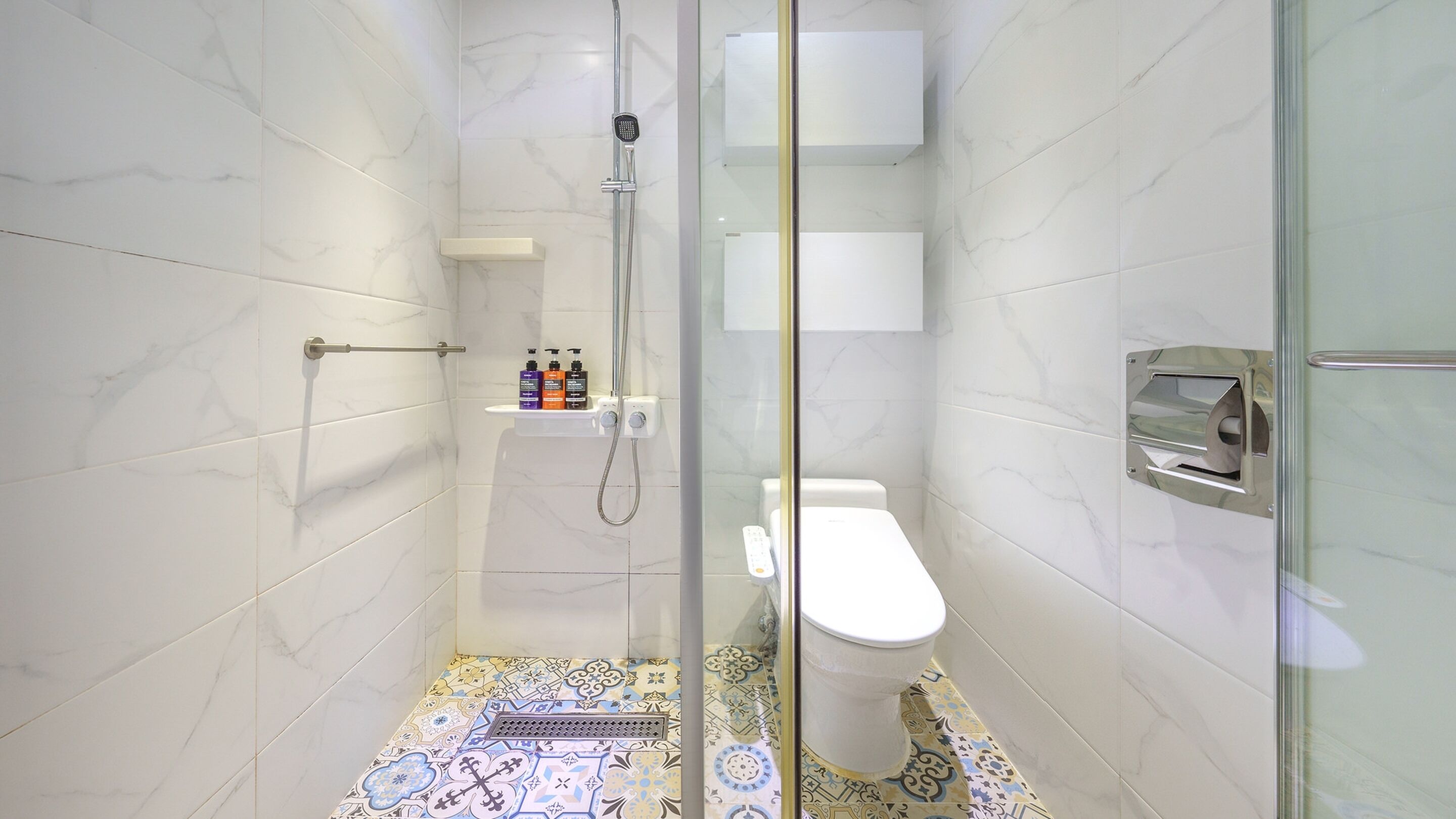 Een moderne badkamer met een douchecabine van glas, een toilet en een wastafel.