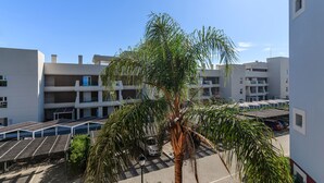 A modern building with a central palm tree, solar panels, and a parking area. - El Rincon del Golf III - Isla Canela Golf GRHIII6P6 (Isla Canela)