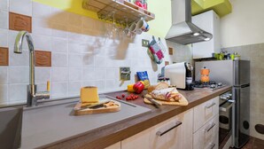 Una cucina moderna con lavello in acciaio inossidabile, forno integrato e una varietà di utensili ed elettrodomestici da cucina.