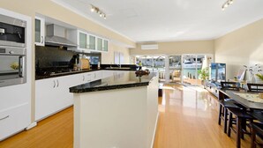 A modern kitchen with white cabinets, stainless steel appliances, and a large island.