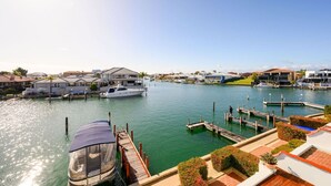 A marina with docked boats, a yacht, and residential buildings.