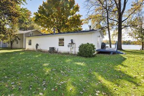 A single-story mobile home with a small porch, a chimney, and a water feature. - Lakefront Home with Dock, Firepit & Private Deck (Bloomingdale)