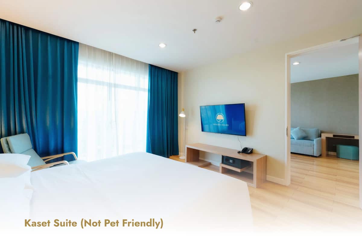Ein Hotelzimmer mit einem großen Bett, einem Fernseher, einem Schreibtisch und einem Sofa.