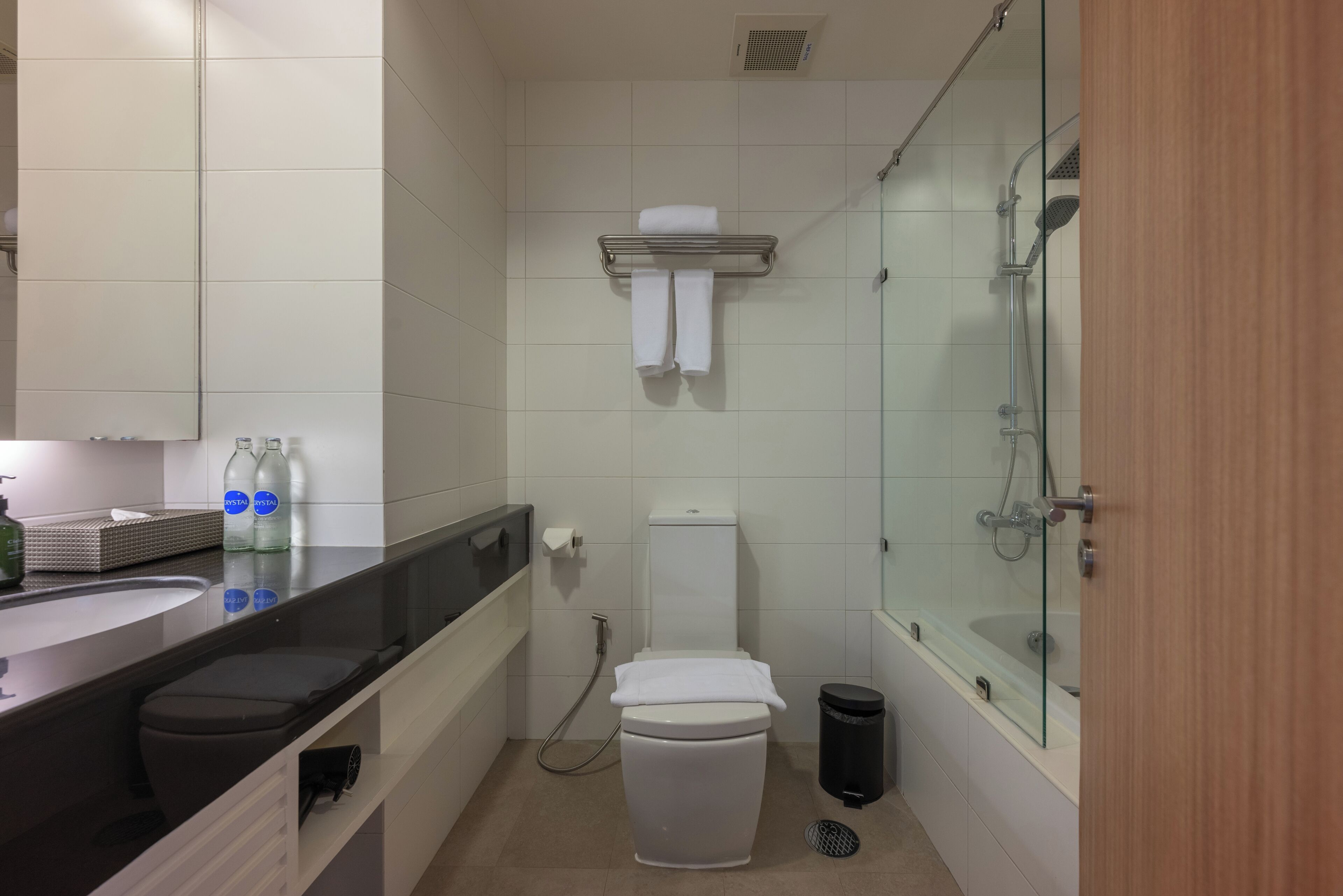 A modern bathroom with a toilet, sink, and glass-enclosed shower.