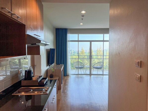 Una cocina moderna con un ventanal y un balcón con mobiliario exterior.