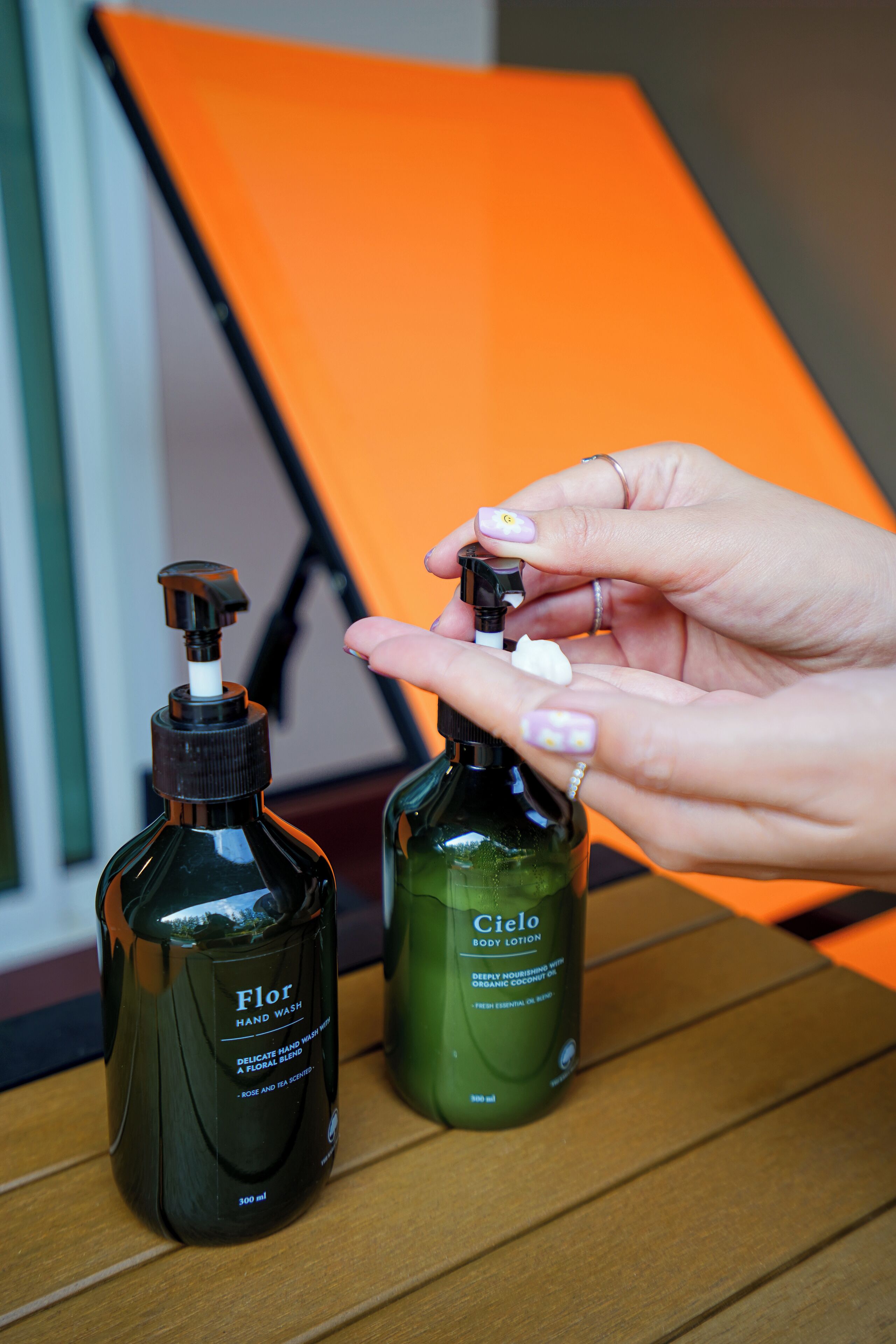 Zwei Flaschen Handseifenlotion auf einer Holztischplatte.