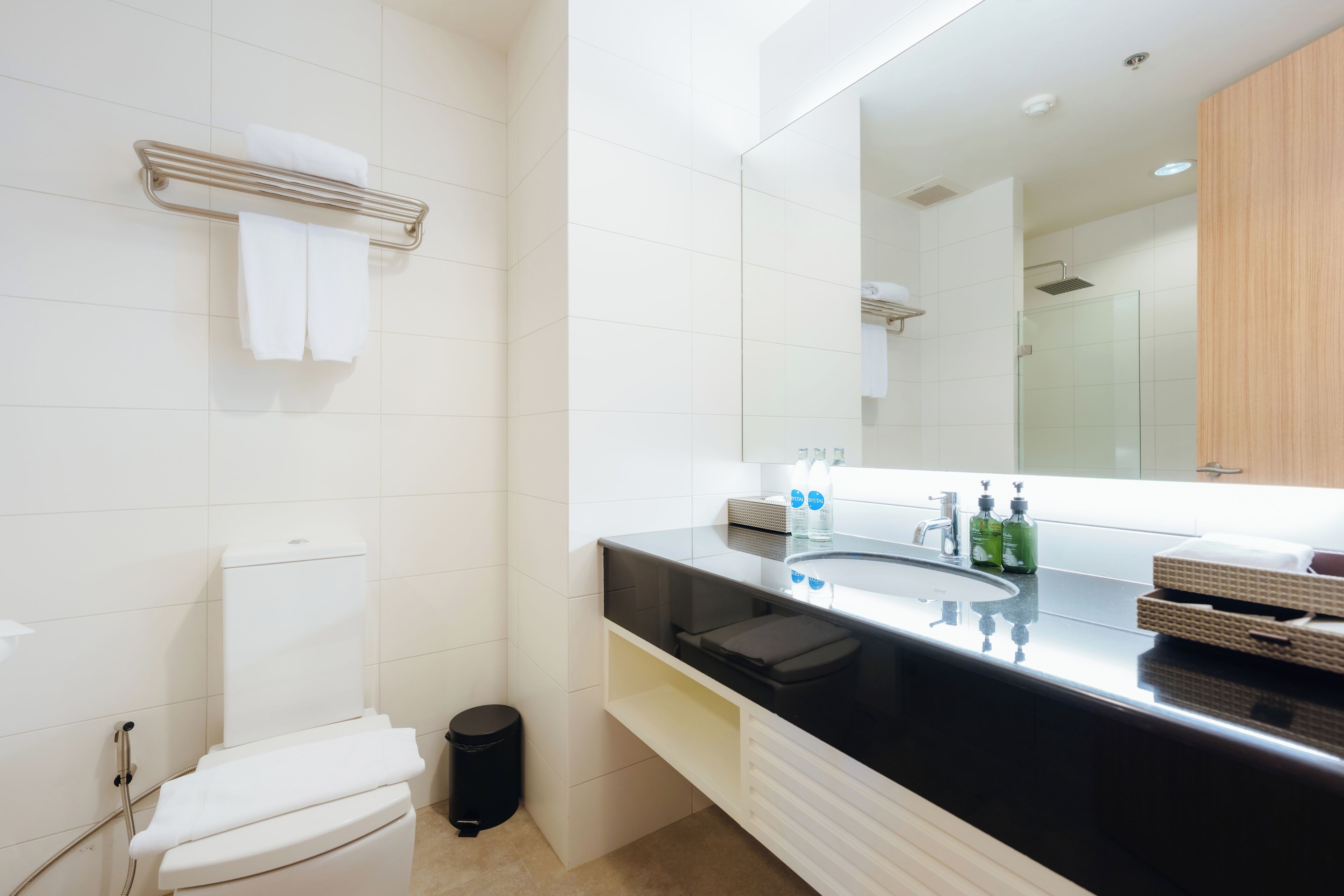 Un baño moderno con inodoro, lavamanos y espejo.