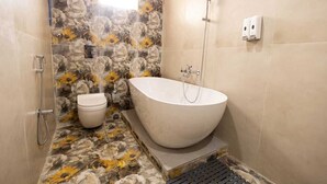 Une salle de bain avec une baignoire sur pieds, des toilettes et un espace douche.