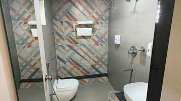 A compact bathroom with a toilet, sink, and shower.