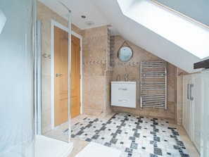 A modern bathroom with a glass shower enclosure, a freestanding bathtub, a vanity with a mirror, and a towel rack. - Luxurious Sheffield Villa With Stunning Views (Sheffield)
