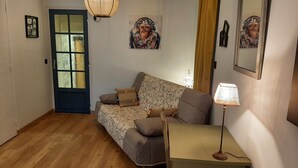 Un salon confortable avec un canapé, une petite table et une lampe.