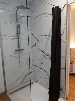 Een douche, een haardroger, handdoeken, toiletpapier