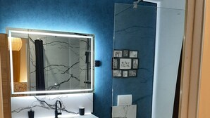 Une salle de bain moderne avec un meuble-lavabo en marbre, un grand miroir et des toilettes.