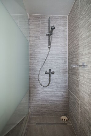 Regadera, secadora de cabello, toallas, papel de baño 