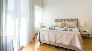 Un dormitorio ordenado con cama, mesita de noche y una silla.