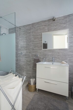 Regadera, secadora de cabello, toallas, papel de baño 