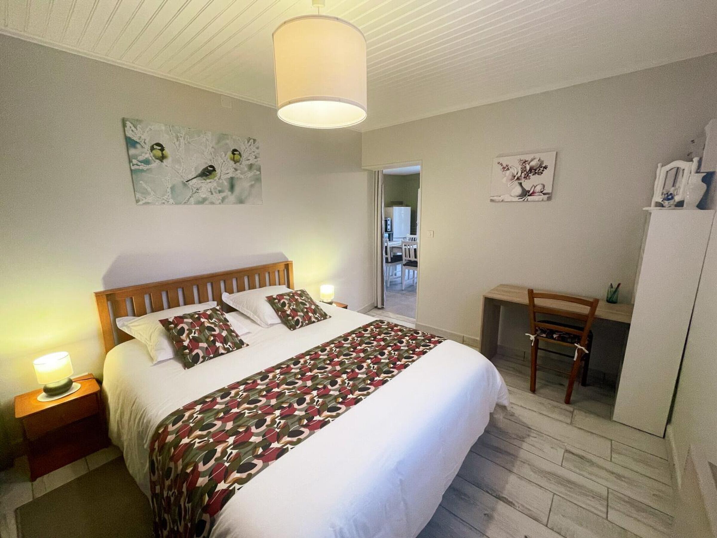 Une chambre à coucher avec un lit, des lampes de chevet, un bureau et une chaise.