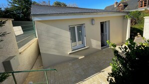 A small, single-story building with a tiled patio, a window, and a door. - Charming cottage in Montbazon with terrace, garden, and parking (Montbazon)