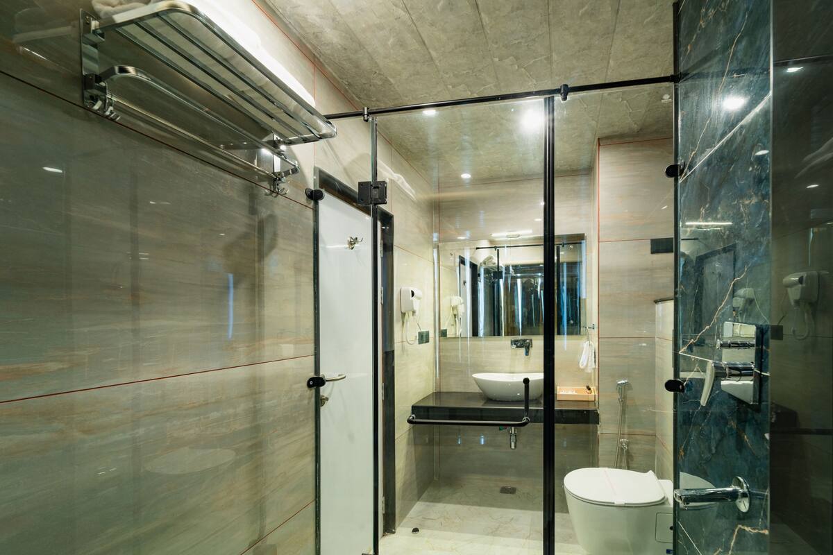 A modern bathroom with a glass-enclosed shower, a sink, and a toilet.