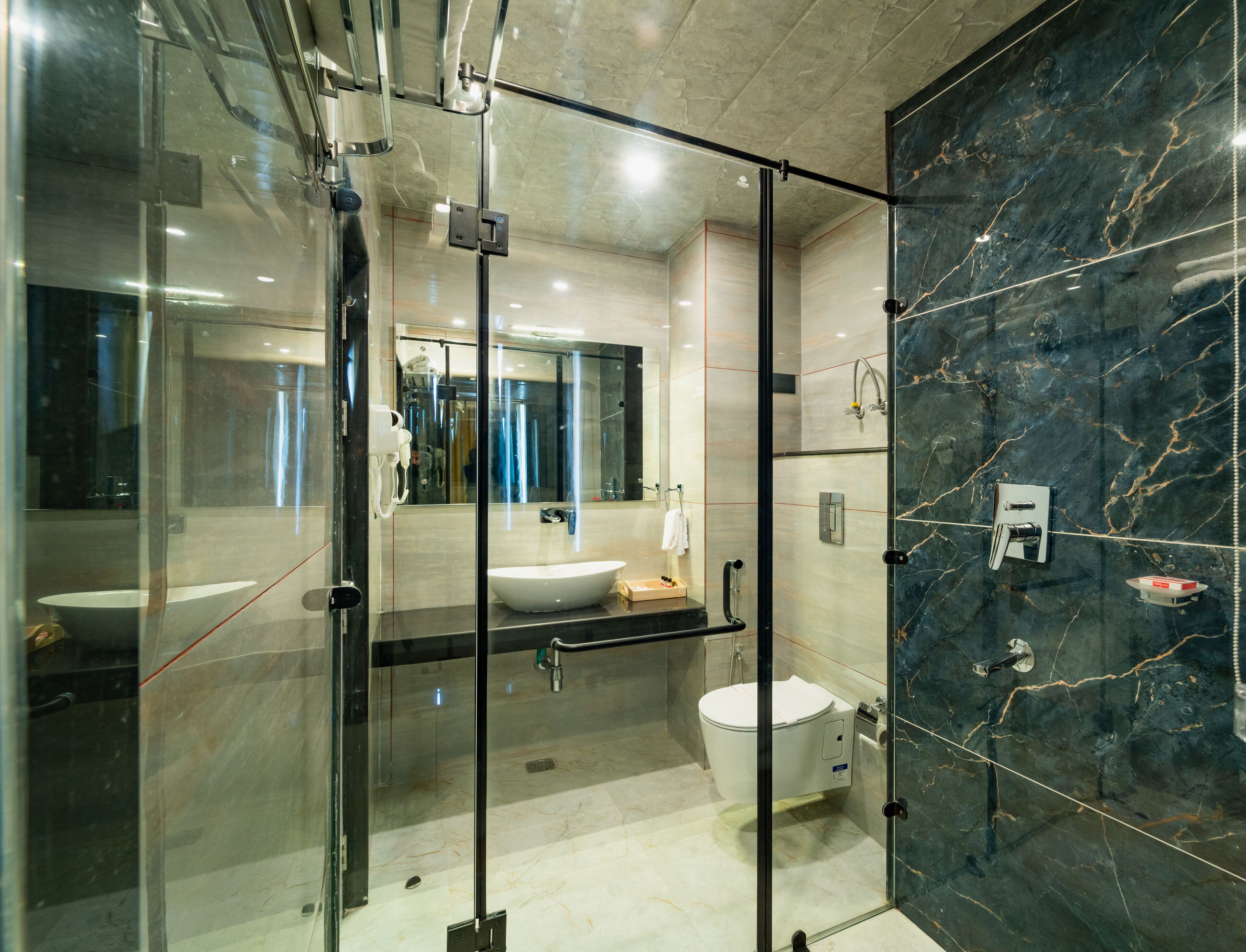 Une salle de bain moderne avec une douche à parois de verre, un meuble-lavabo et des toilettes.