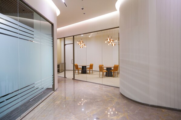 A modern conference room with glass walls, a marble floor, and a round table with chairs. - 0484 Aero Lounge - Terminal 2, Cochin Airport Hotel (Aluva)