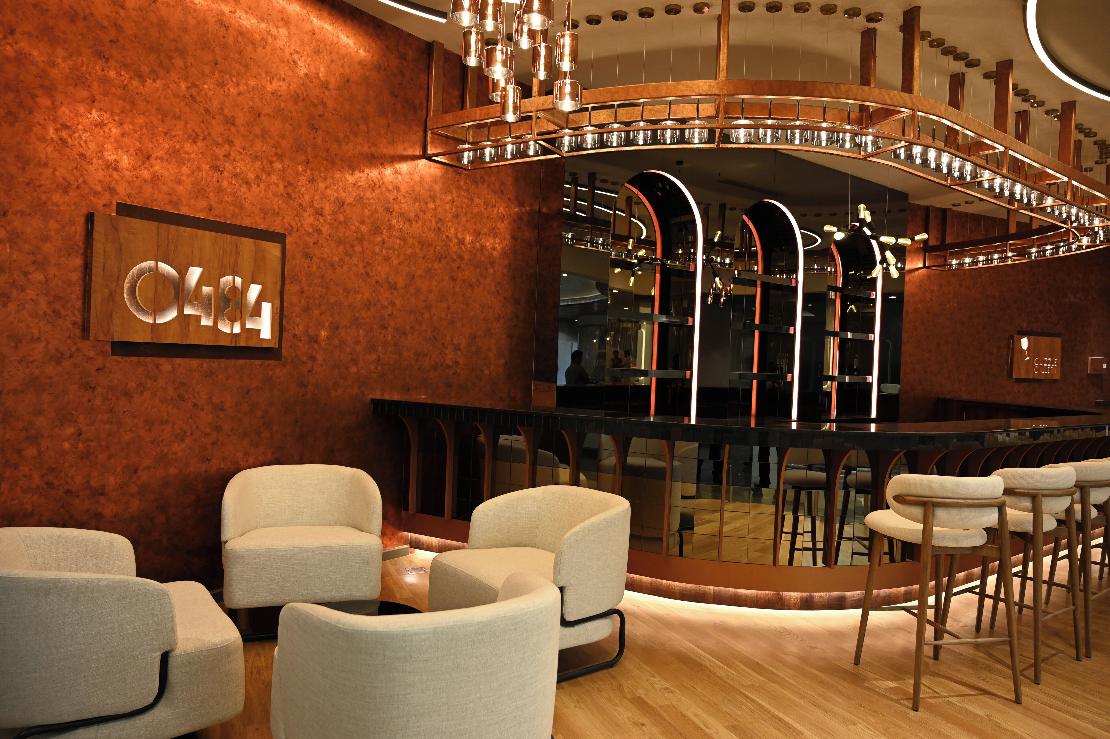 A modern bar area with a curved ceiling and a wooden sign with the number 0484.