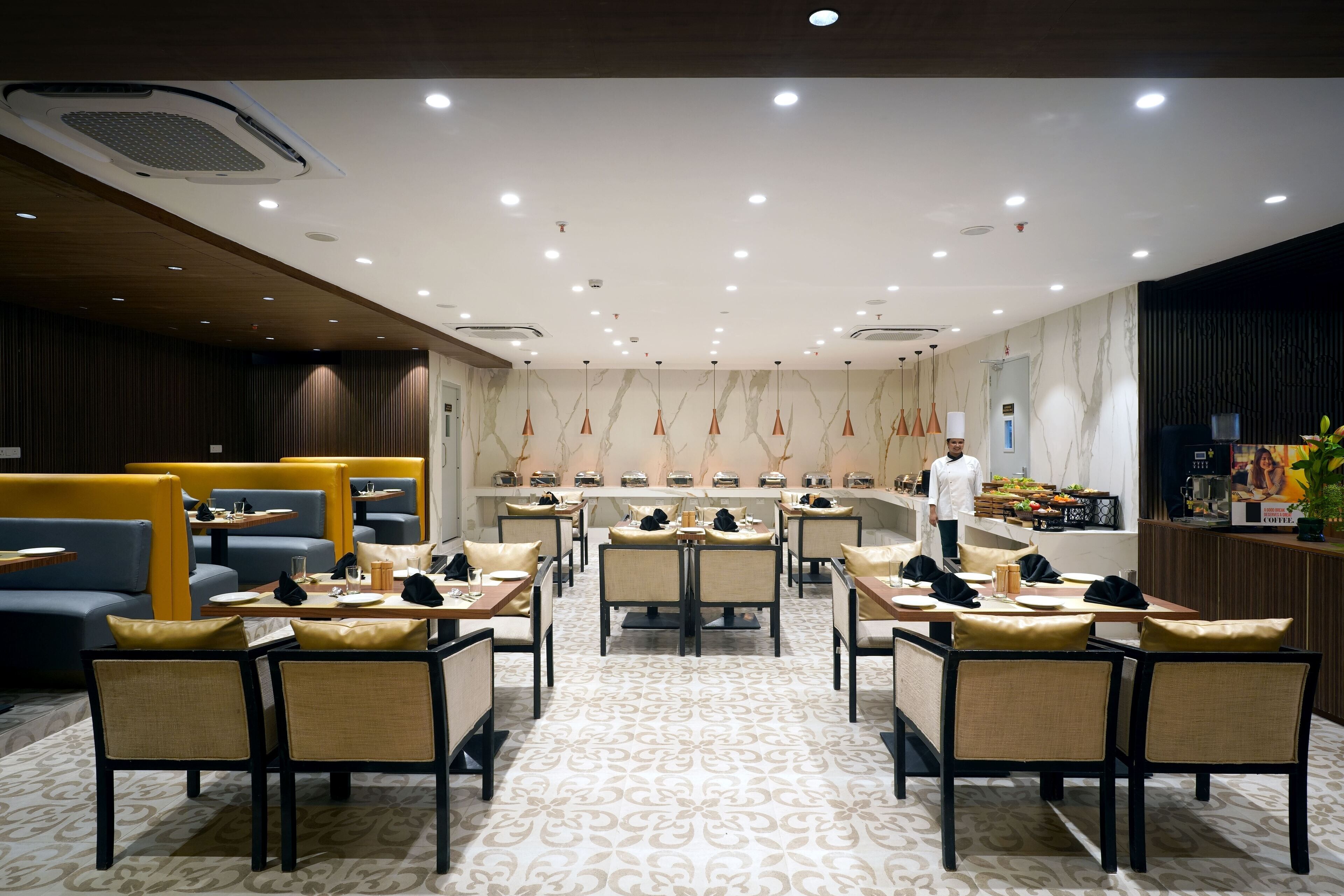 A modern restaurant with high tables and chairs, a bar area, and a chef in uniform.